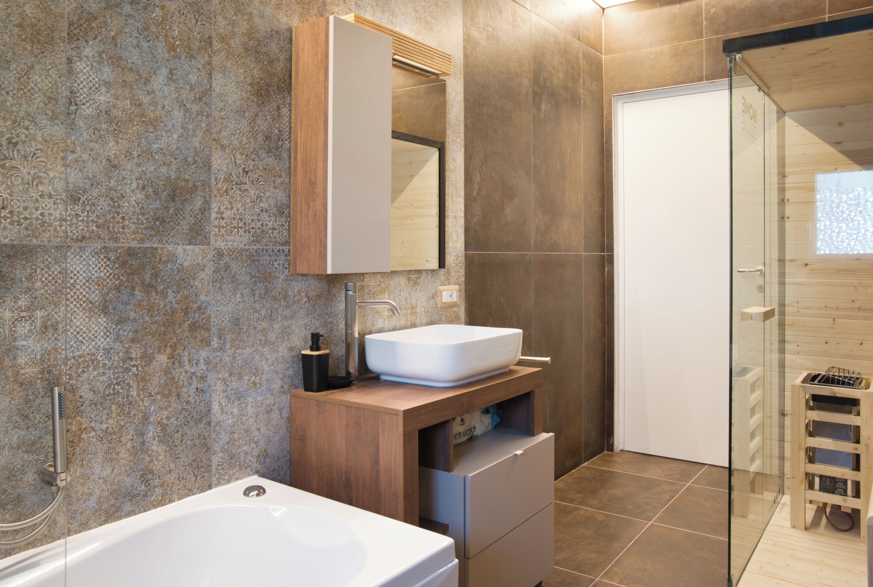 Ein modernes Badezimmer mit einer freistehenden Badewanne, einem Holzwaschtisch mit Spüle und einer Duschkabine aus Glas.