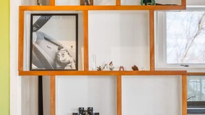 Une étagère en bois à plusieurs niveaux, agrémentée de divers objets décoratifs, notamment des figurines et une photographie encadrée.