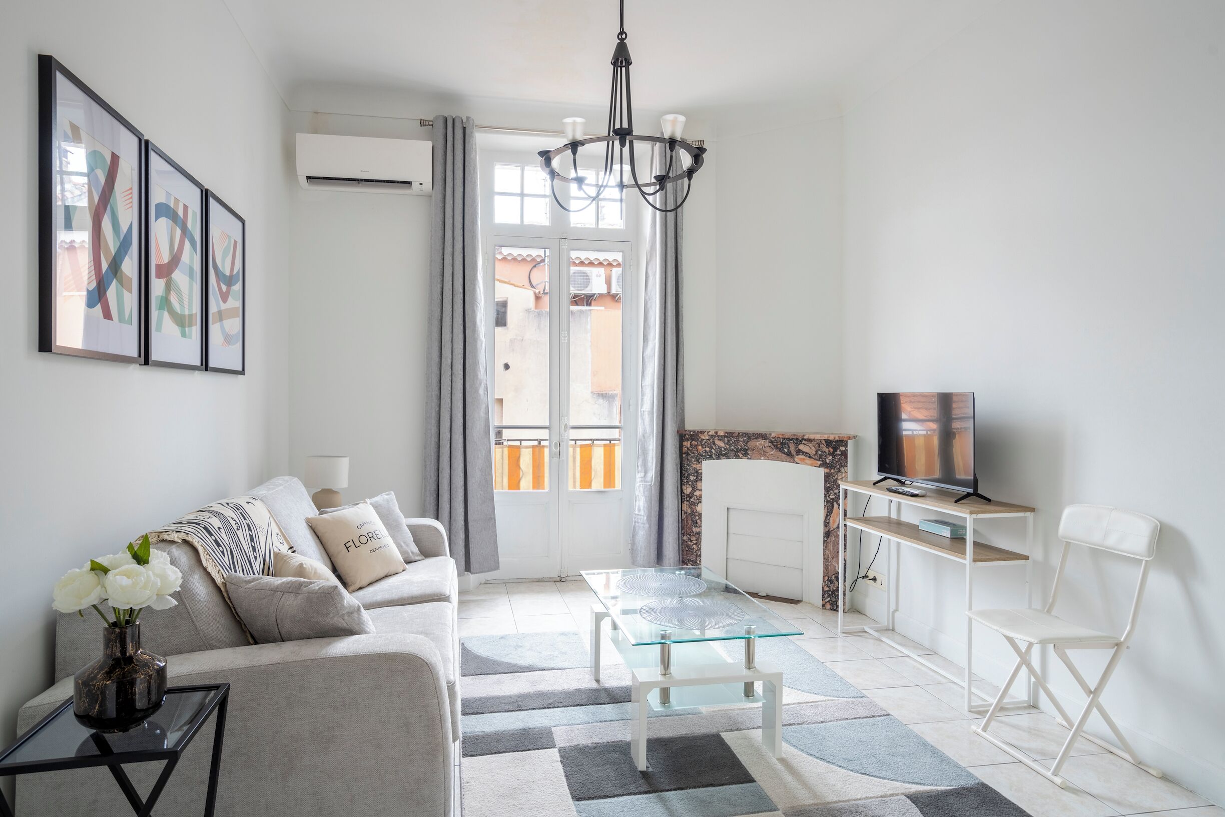 A modern living room with a sofa, coffee table, TV, and artwork on the wall.