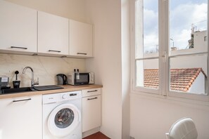 A compact kitchen with a washing machine, a microwave, and a sink. - Les Tomettes d'Antan avec balcon en plein Cannes (Cannes)
