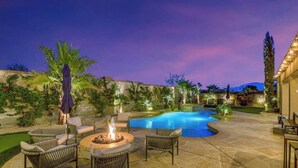 A backyard with a swimming pool, outdoor furniture, and a fire pit.