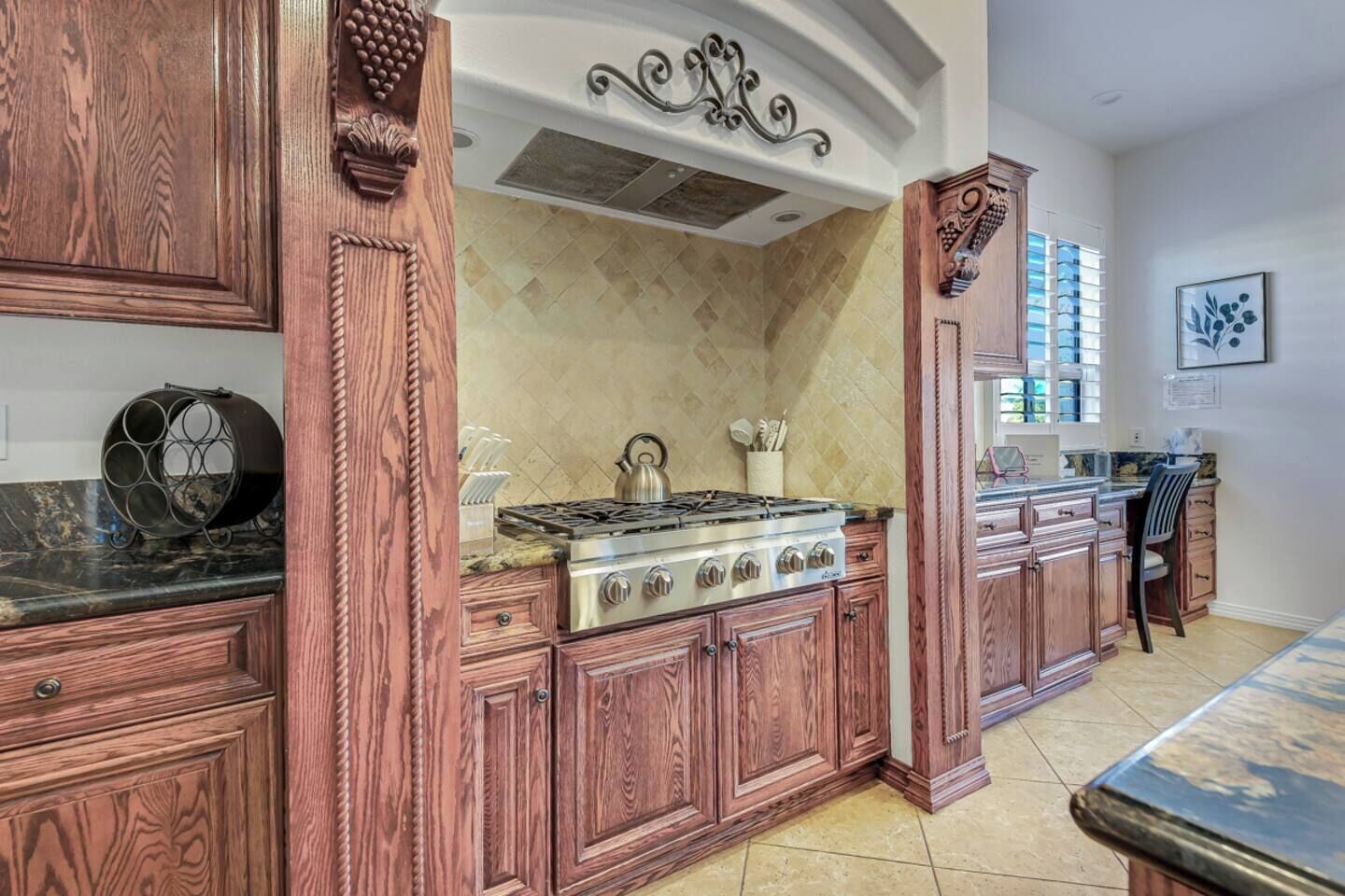 A kitchen with wooden cabinetry, a gas stove, and a tiled backsplash.