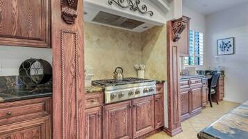 A kitchen with wooden cabinetry, a gas stove, and a tiled backsplash.