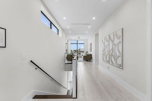 Ein modernes Interieur mit einer Treppe, einem Essbereich und Kunstwerken an den Wänden.