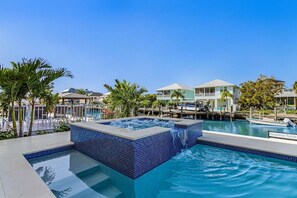 Ein Pool mit Whirlpool, umgeben von Palmen und einer Marina.
