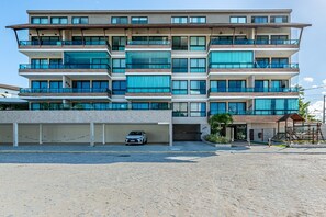 Un hôtel à plusieurs étages doté d’un parking couvert et d’une entrée sécurisée par un portail.