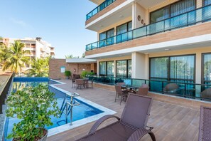Un hôtel doté d’une piscine, d’un espace extérieur aménagé et offrant une vue sur d’autres bâtiments.