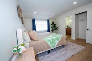 A bedroom with a bed, bedside table, and a plant. - Family friendly 3-bedroom house with AC in Huntington Beach (Huntington Beach)