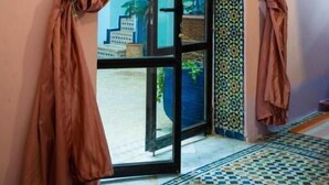 Una habitación con un amplio arco de entrada, suelo con diseño y vistas a una escalera.