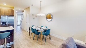 Eine moderne Küche mit Essbereich, einer Treppe und einem an der Wand befestigten Spiegel.