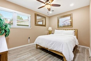 A bedroom with a bed, a ceiling fan, a window with blinds, and a plant. - 6 Mi to Dtwn: Charming Home Little Rock (Little Rock)