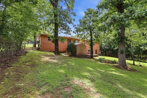 A residential property with a brick house, a wooden shed, and a well-maintained lawn.