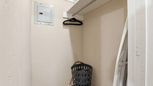 A corner of a room with a laundry basket, a white door, and a light switch on the wall. - Peaceful North Little Rock Home w Backyard! (North Little Rock)