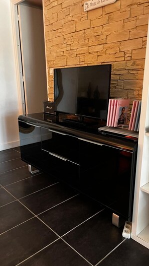 Eine schwarze Unterhaltungsanlage mit einem Flachbildfernseher, einer Stereoanlage und einem Bücherregal.