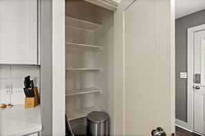 A kitchen with white cabinets, a knife block, and a trash can. - Charming Bungalow - Walk to Georgetown Square (Georgetown)