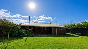 A single-story house with a brick exterior, a covered porch, and a well-maintained lawn.