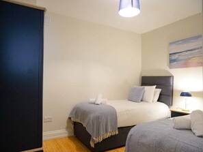 Ein Schlafzimmer mit einem Bett, Nachttischen, einer Lampe und einem Bild an der Wand.