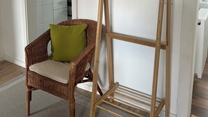 A room with a wooden coat rack, a wicker chair with a cushion, and a wall-mounted deer head decoration. - Lovingly Renovated Apartment in Hausen (Hausen)