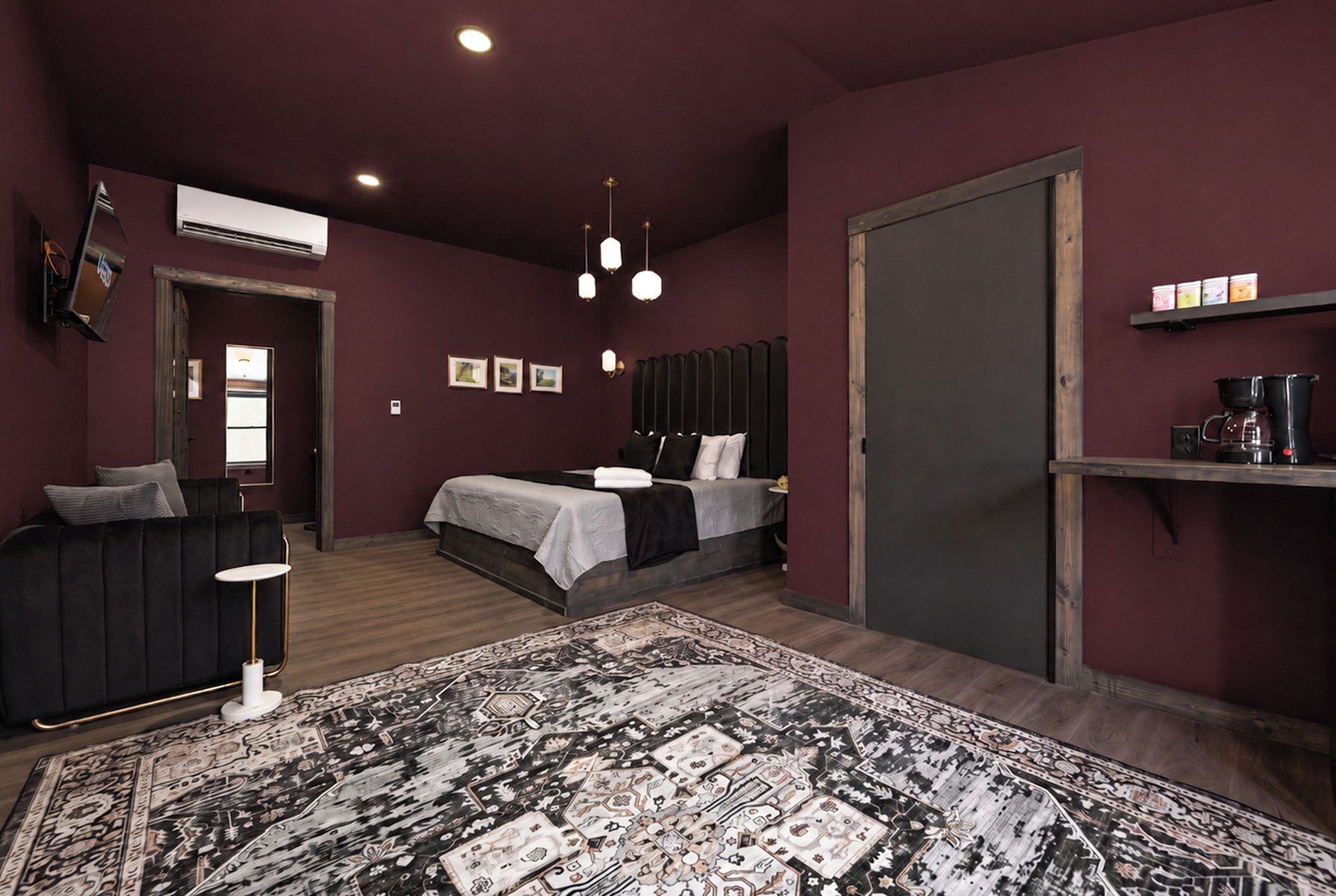 A modern bedroom with two beds, a large rug, and a coffee machine.