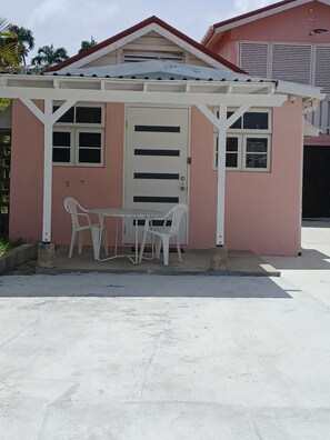 A small structure with a white roof and a door, featuring two white plastic chairs and a table. - 1BR across from Worthing Beach, Christ Church (Bridgetown)
