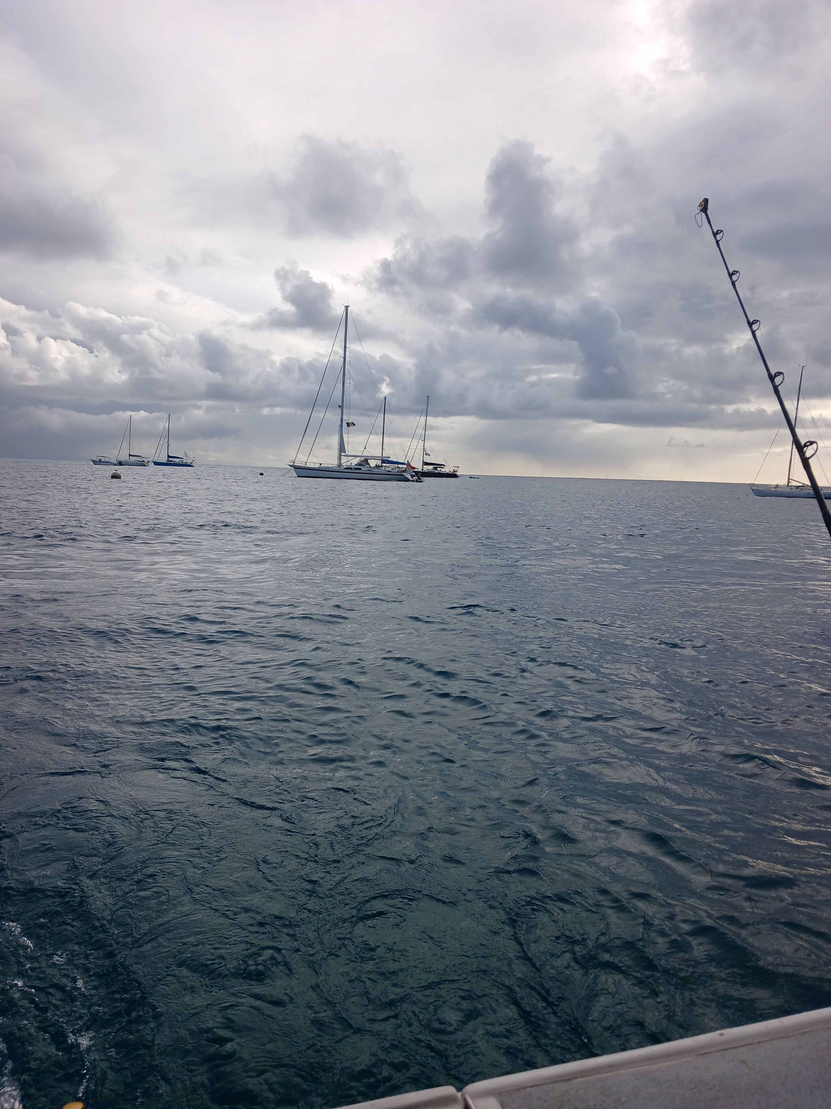 Ruhiges Meer mit Segelbooten und einer Angel.