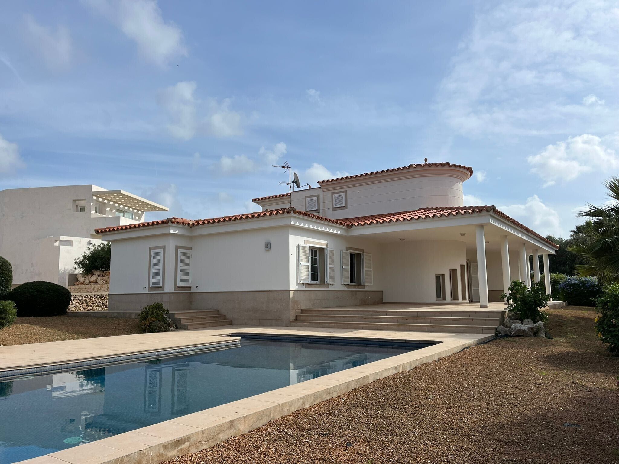 Una casa de dos pisos con piscina delantera.