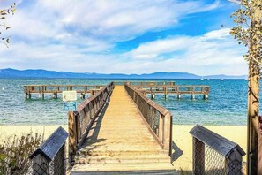 A wooden pier leading to a dock with a clear view of the sea and distant mountains. - Modern Tahoe Retreat - Your Place to Unwind (South Lake Tahoe)