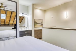 Un dormitorio con cama, mesita de noche, espejo, cómoda y un cuadro en la pared.