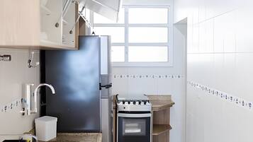 A kitchen with a built-in oven, a window, and a tiled backsplash.