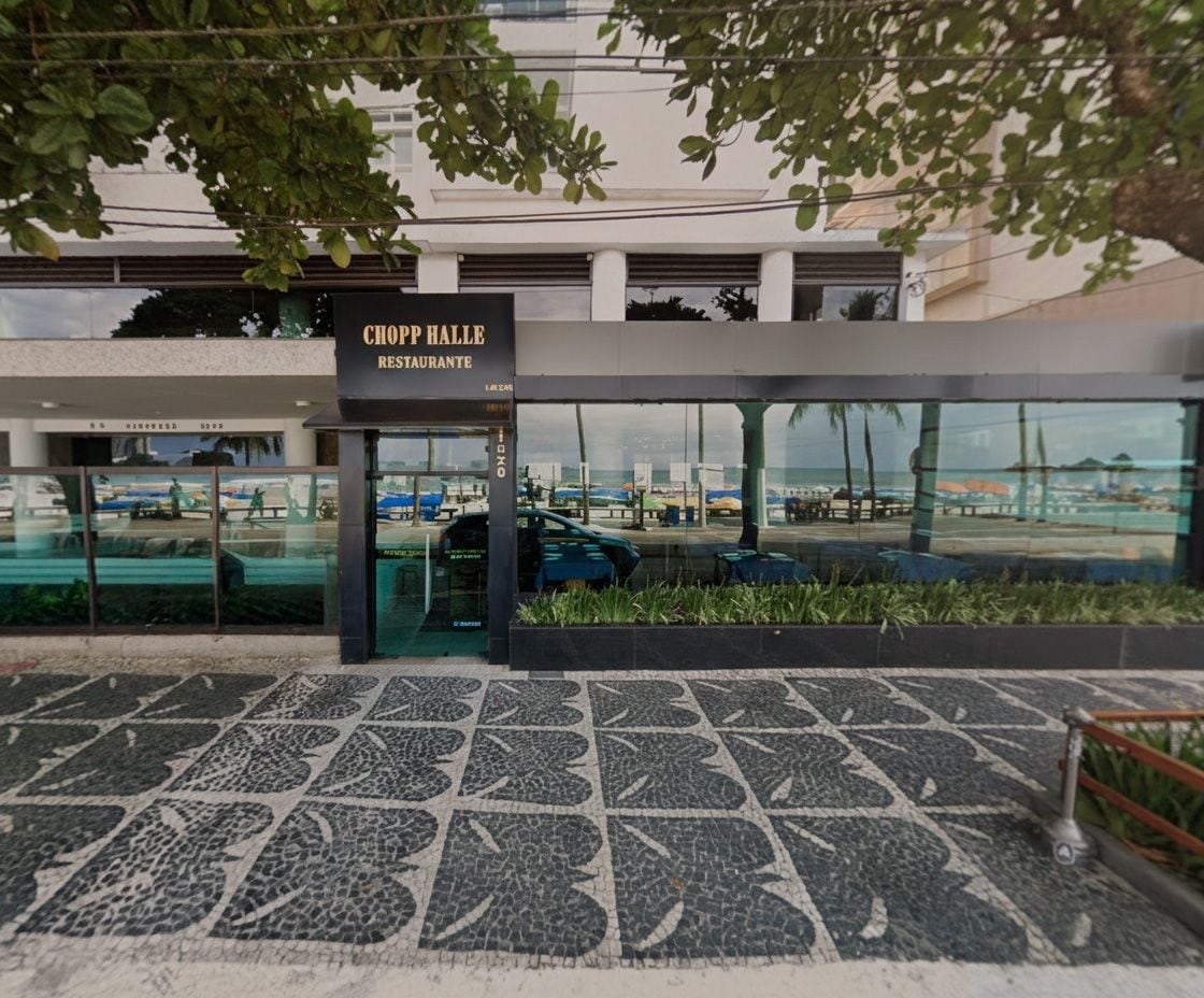 L’extérieur du restaurant Chop Hall présente un design moderne, de grandes fenêtres en verre et une zone d’entrée pavée.