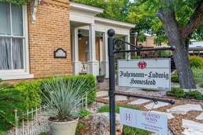 A property named Fuhrmann-Ludwig Homestead with a sign indicating it is a vacation rental. - Historic Ludwig Haus, Downtown, Pet Friendly! (New Braunfels)