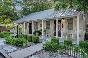 A two-story building with a covered porch, stone walls, and a sign indicating a telegraph station. - Telegraph Station #1, Downtown, Pet friendly! (New Braunfels)