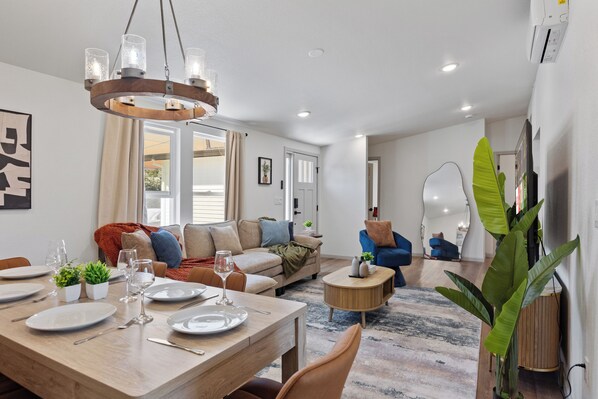 A modern living room with a dining area, a sofa set, and a coffee table.