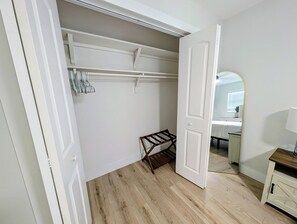 A room with a wooden floor, a white door, a mirror, and a wooden bench. - A Haven of Sun and Fun in Largo; A Private Oasis in the heart of everything (Largo)