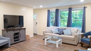 A living room with a sofa, armchairs, a coffee table, and a television. - Comfort and Convenience in Renovated 3 Bedroom Home near UConn (Tolland)