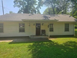 A single-story house with a front porch, a mailbox, and a small front yard.