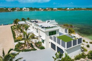 Ein modernes Strandhaus mit Dachterrasse, Pool und Meerblick.