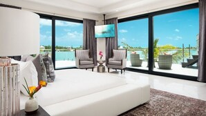 Ein modernes Hotelzimmer mit einem großen Bett, einem Flachbildfernseher und einem Balkon mit Blick auf einen Pool.