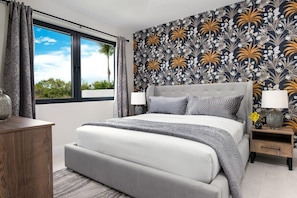 A bedroom with a large bed, a nightstand, a bedside table, and a window with curtains. - Rooftop Villa w/ Pool & Hot Tub in Chalk Sound (Providenciales)