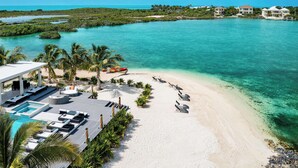 Ein Resort mit Pool, Liegestühlen und Strand.
