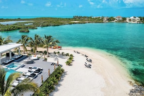 Ein Resort mit Pool, Liegestühlen und Strand.