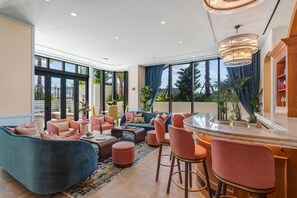 A spacious living area with a large sofa, multiple chairs, a coffee table, and a bar area with stools. - Luxury Miami 1BR Apt with Pool  (Miami)