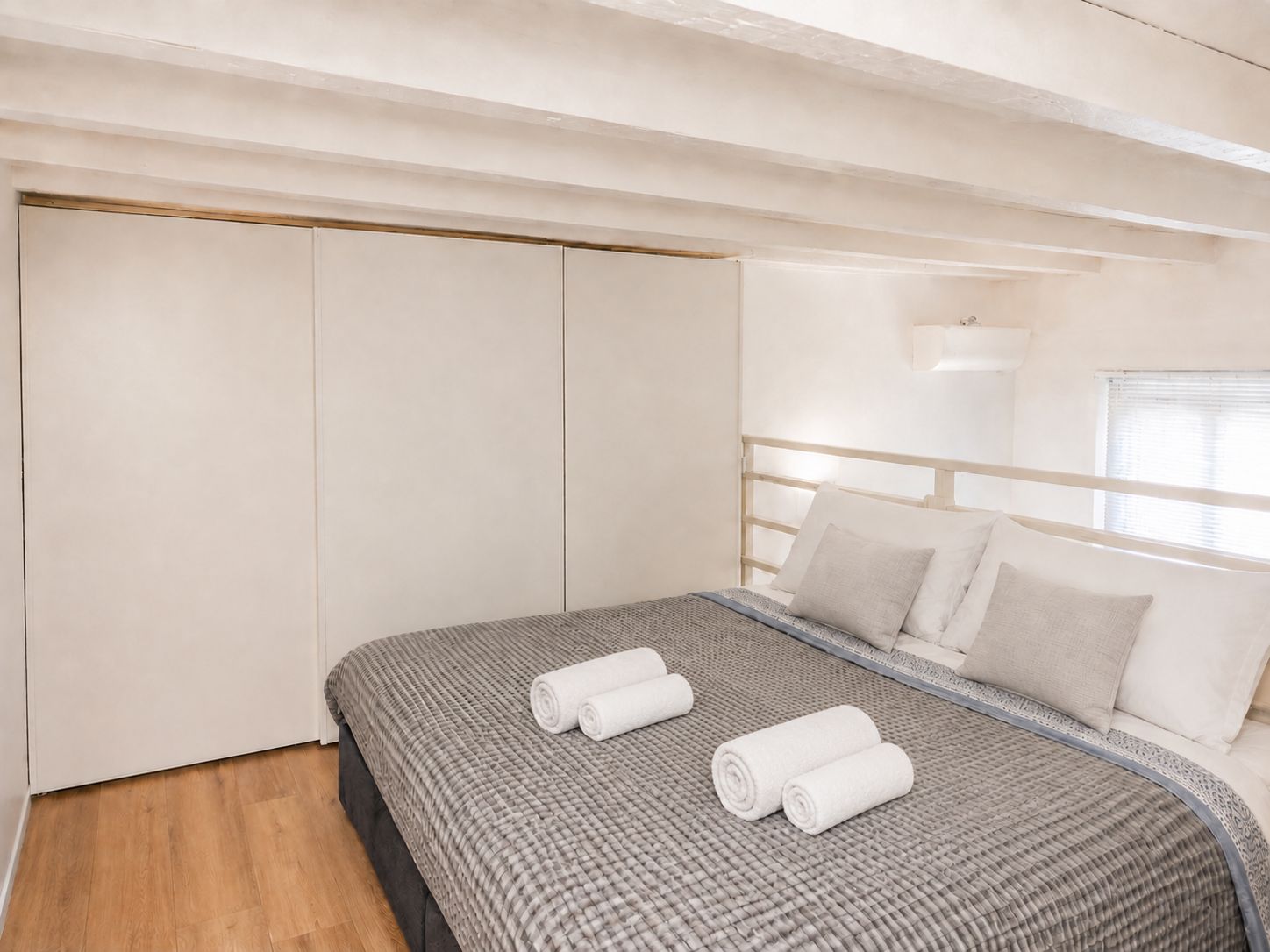 Een slaapkamer met een bed, een kledingkast en een raam.