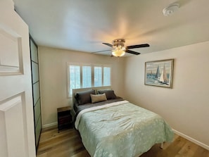 A bedroom with a bed, a ceiling fan, a window with blinds, and a framed picture on the wall. - 2BDR Belmont Shore Retreat <> Steps from the Beach (Long Beach)