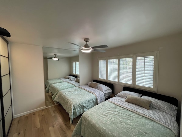 A bedroom with two beds, a ceiling fan, and a large mirror. - 2BDR Belmont Shore Retreat <> Steps from the Beach (Long Beach)
