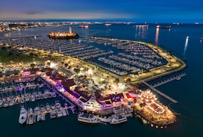 A marina with boats docked, a lighthouse, and a building with a red roof. - 2BDR Belmont Shore Retreat <> Steps from the Beach (Long Beach)