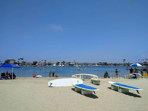 A beach with surfboards, umbrellas, and a clear sky. - 2BDR Belmont Shore Retreat <> Steps from the Beach (Long Beach)