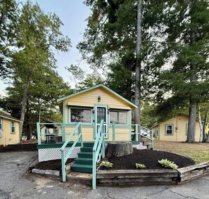 A small, single-story cabin with a porch and steps leading to the entrance. - Cabin 23 at Historic Sandy Point w. Boat Slip (Alton)
