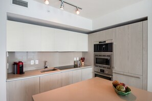A modern kitchen with a built-in oven, microwave, and coffee maker. - Lyfe Resort & Residences (Hollywood)
