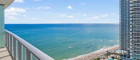 A high-rise hotel with a pool area and beach view.